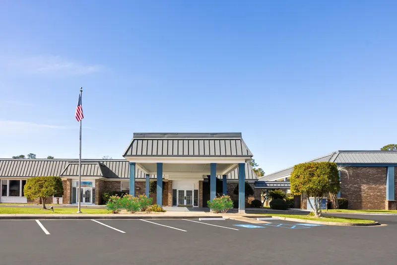 Main entrance of the hotel under a covered canopy on a sunny day