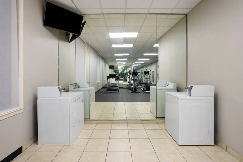 Washers and dryers in front of the mirrored fitness center