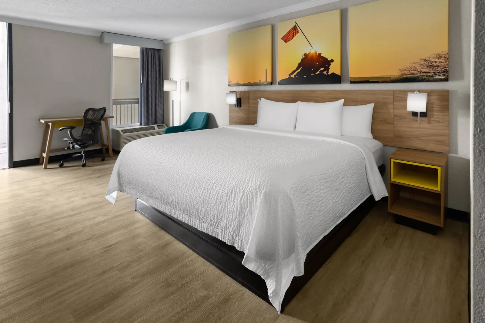 King room with a desk and office chair, a teal armchair and a wood headboard