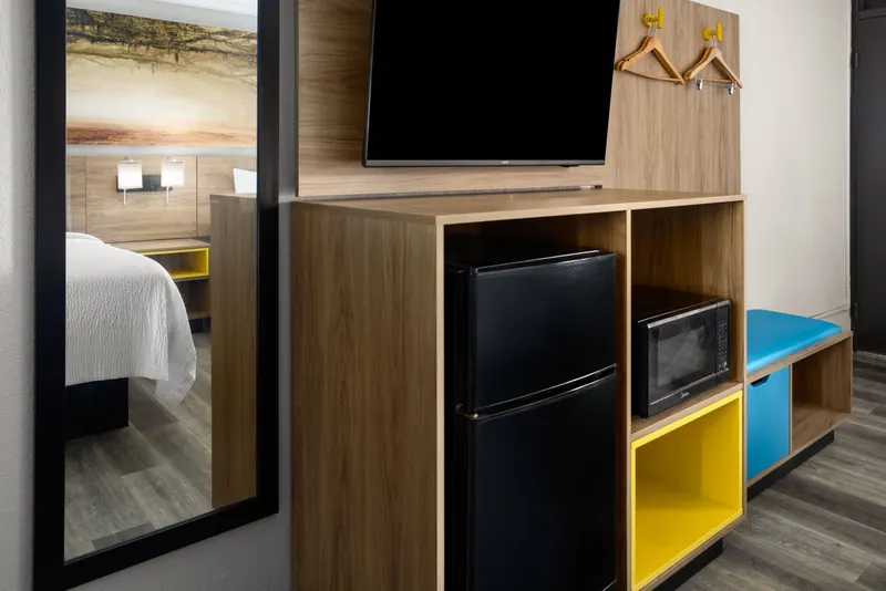 Wall unit with flat-screen TV, mini-refrigerator, microwave and coat hooks