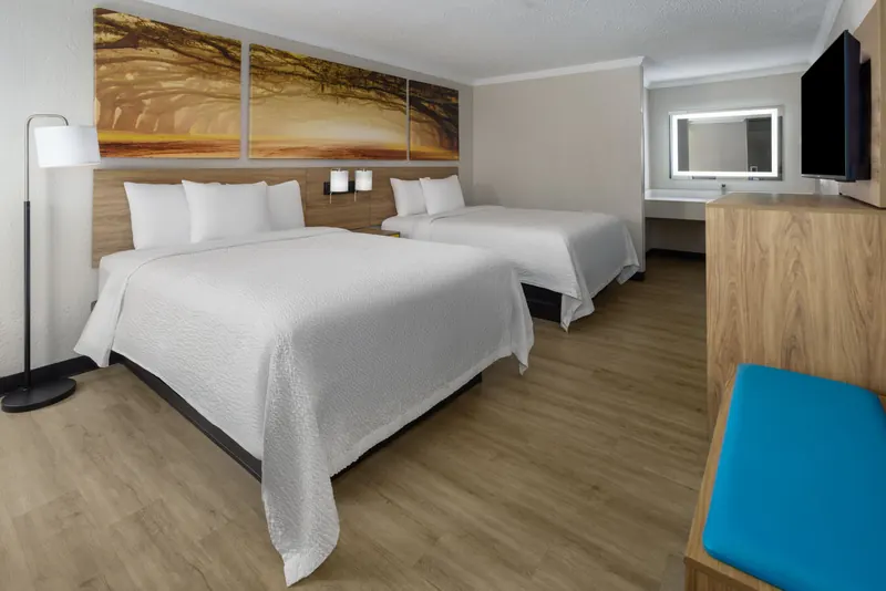 Room with two queen beds under wall art of live oak trees
